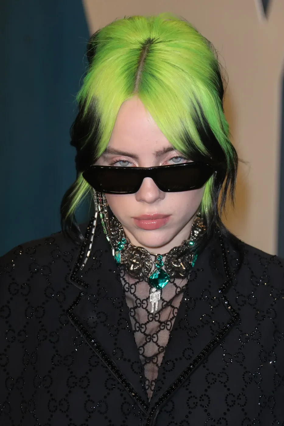 Front portrait with neon-green color covering the top and split fringe of a short black bob.