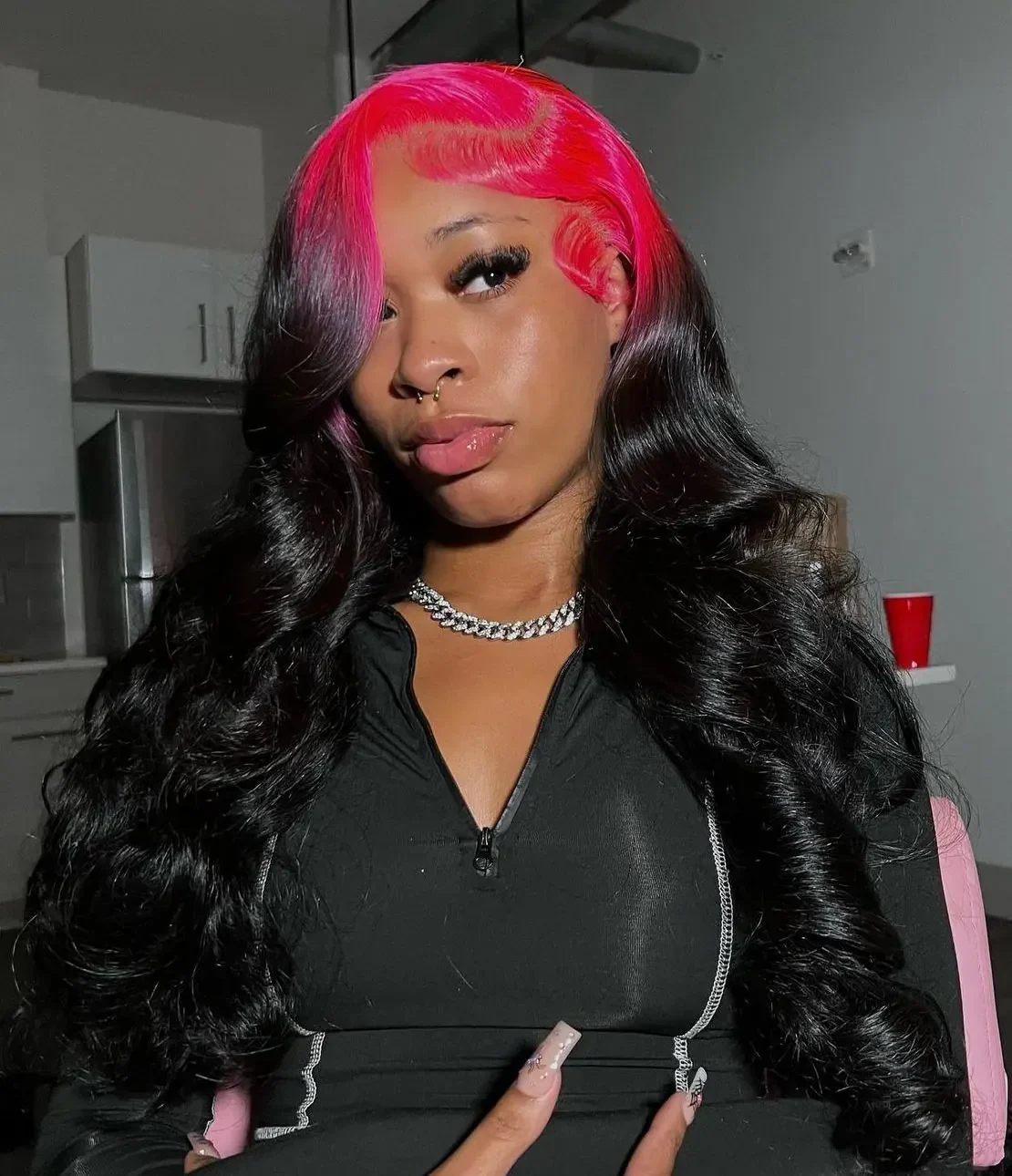 Front portrait of long black body-wave hair with a broad hot-pink panel sweeping across the top and one side of the hairline.