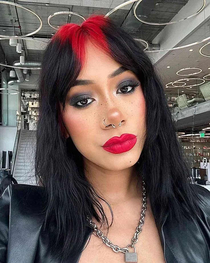 Woman with long sleek black hair and a vivid crimson-red panel across the front center root zone.