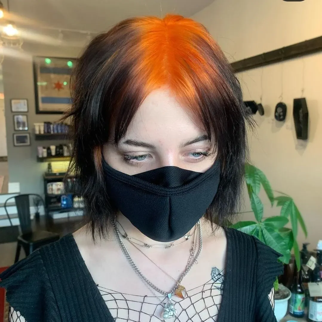Front portrait of a medium black shag with orange-red color beginning at the roots beneath a split fringe.