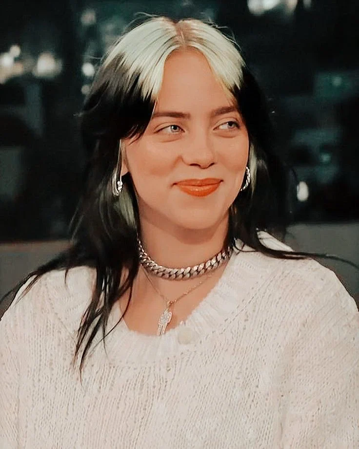 Woman with a medium black layered shag and silver-white color centered over the part.