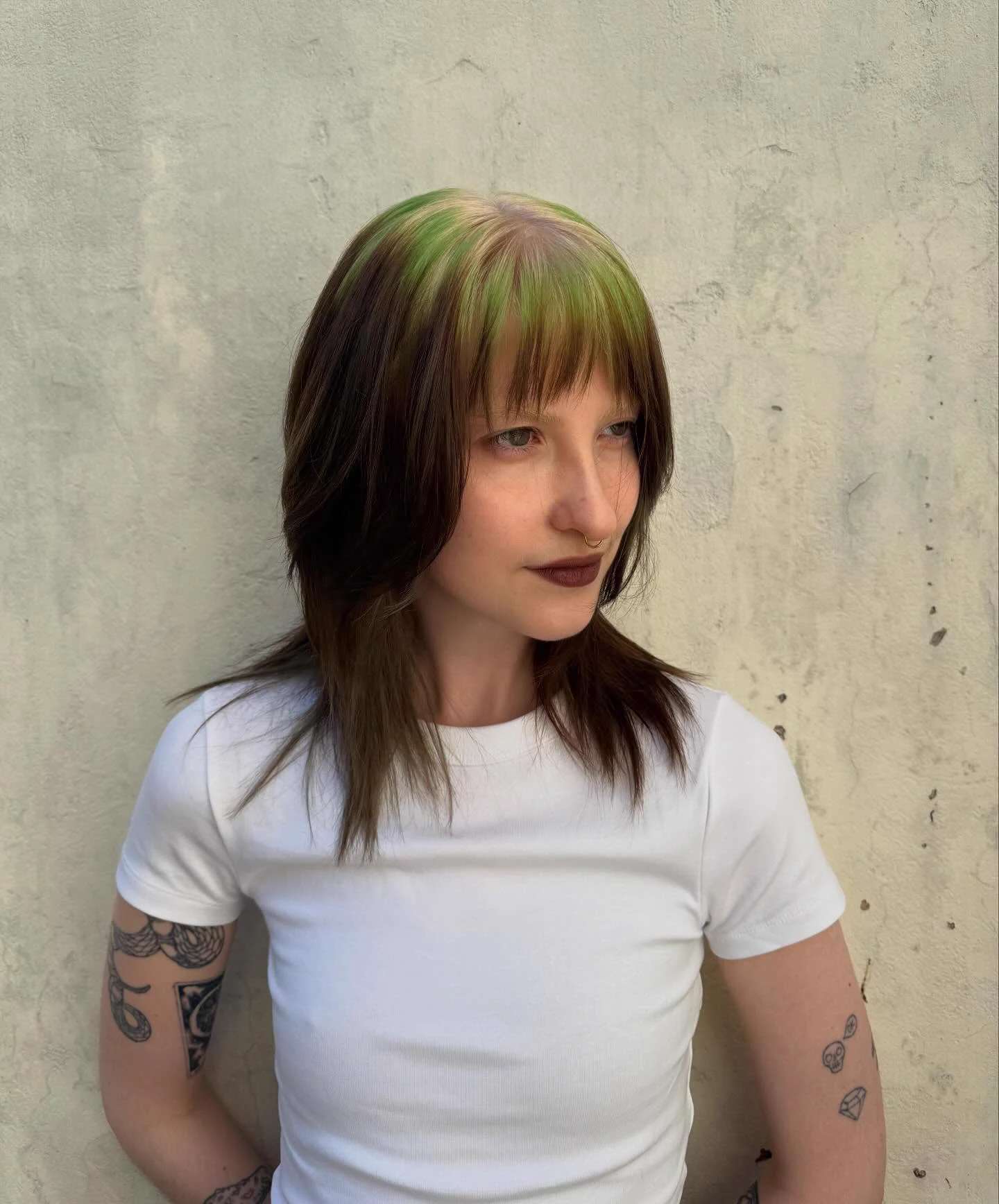 Brown and black layered wolf cut with green ghost roots through the full top and fringe.
