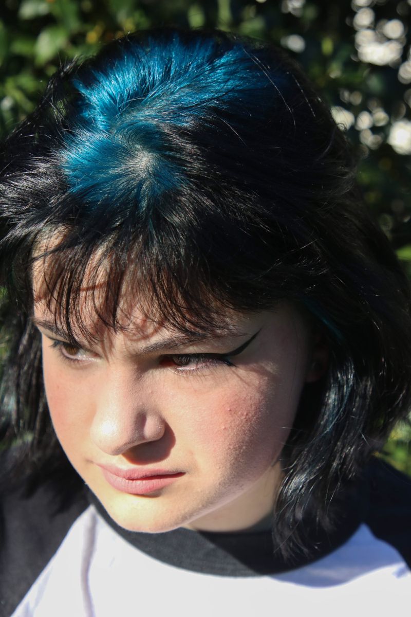Black hair with Blue Teal ghost roots, Short Layered Shag, Outdoor Portrait.