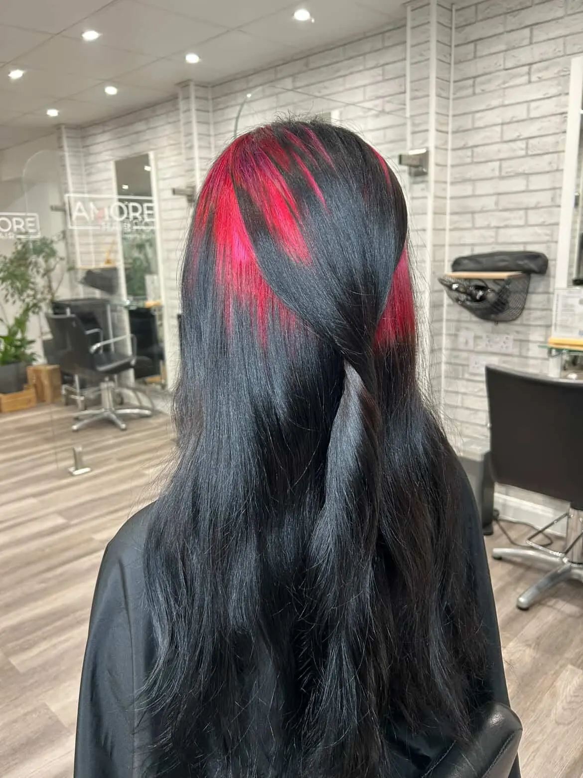 Long black soft waves with crimson-red ghost roots visible from the back.