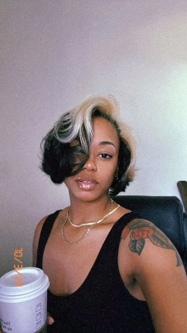 Short black sleek bob with asymmetrical platinum blonde ghost roots.