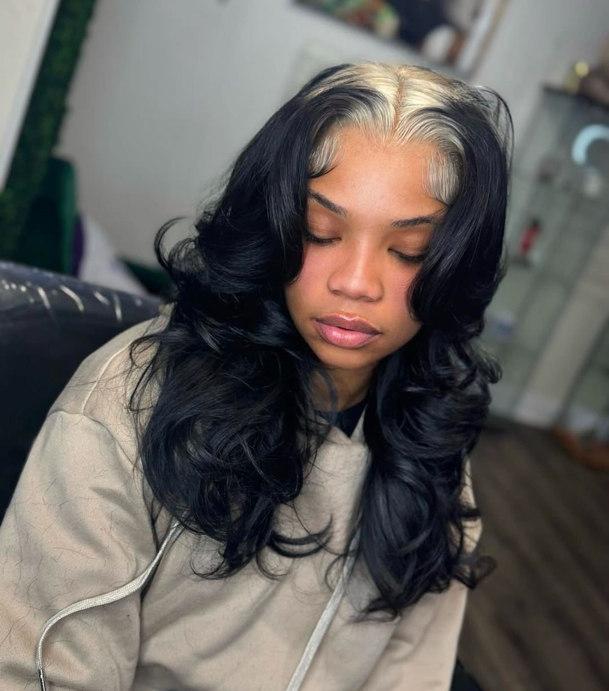 Soft black waves with platinum blonde ghost roots and a center-part shape.