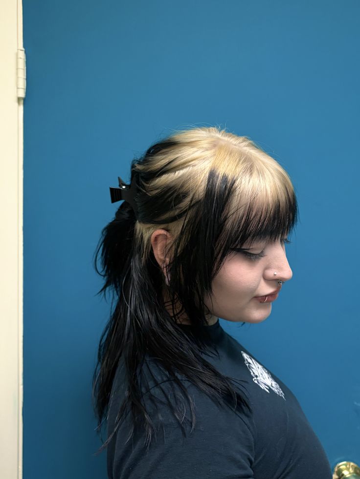 Black half-up style with creamy blonde ghost roots and blunt bangs.