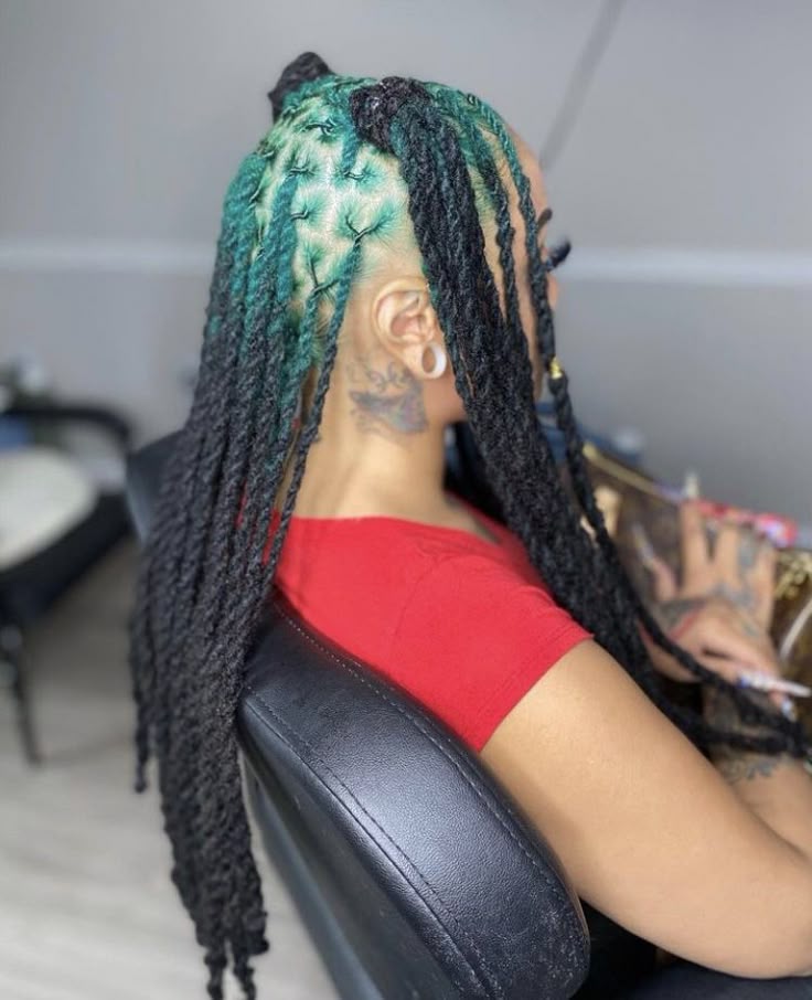 Long black locs with teal green ghost roots through a side-panel placement.