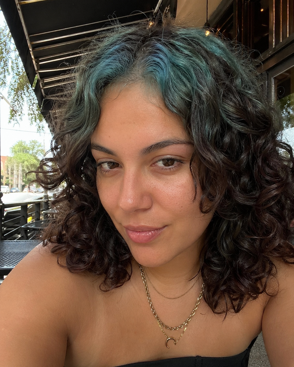 Black hair with Teal Green ghost roots, Medium Curly Bob, Outdoor Portrait.
