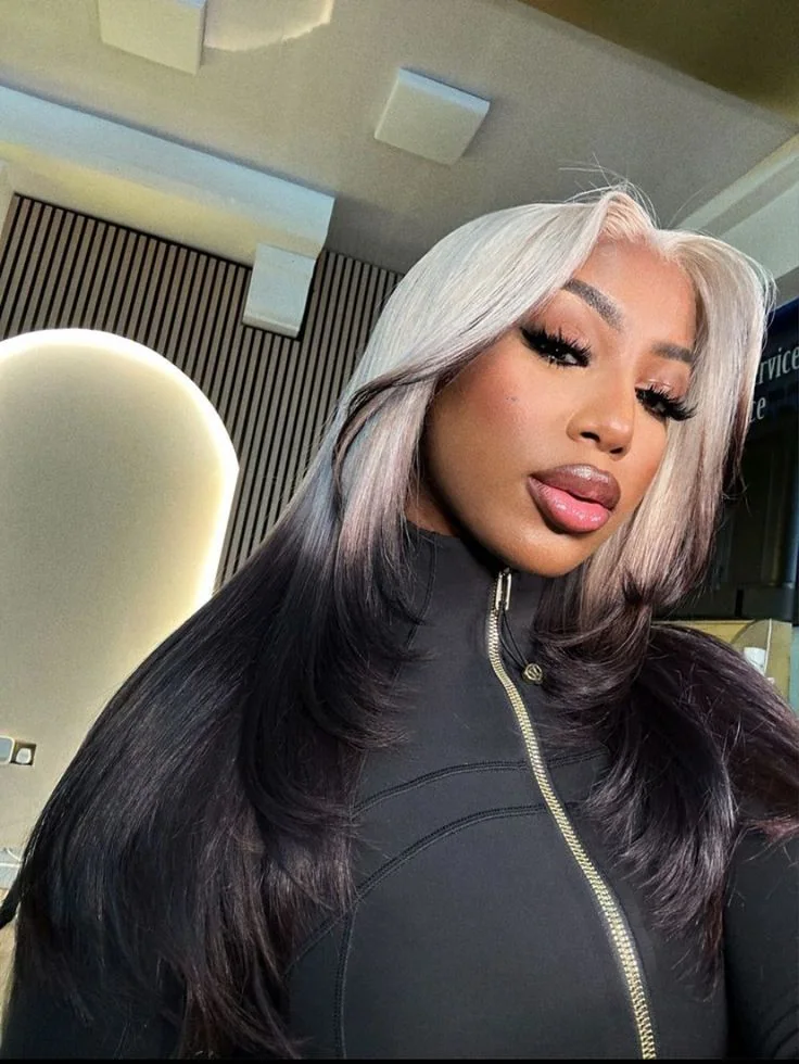 Long black glam waves with silver-white ghost roots through a side part.