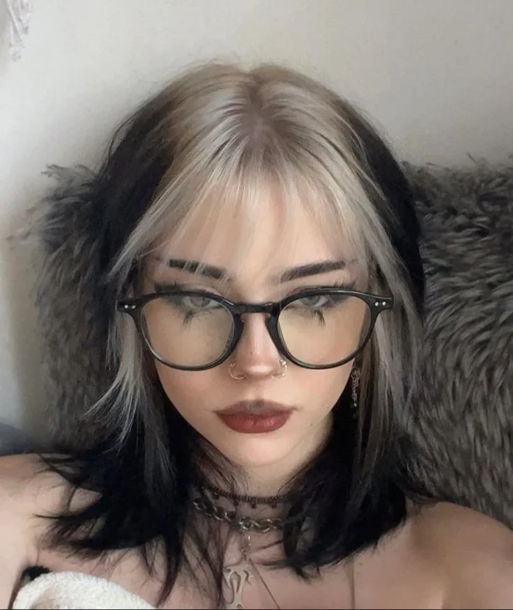 Medium black messy shag with silver white ghost roots and wispy bangs.