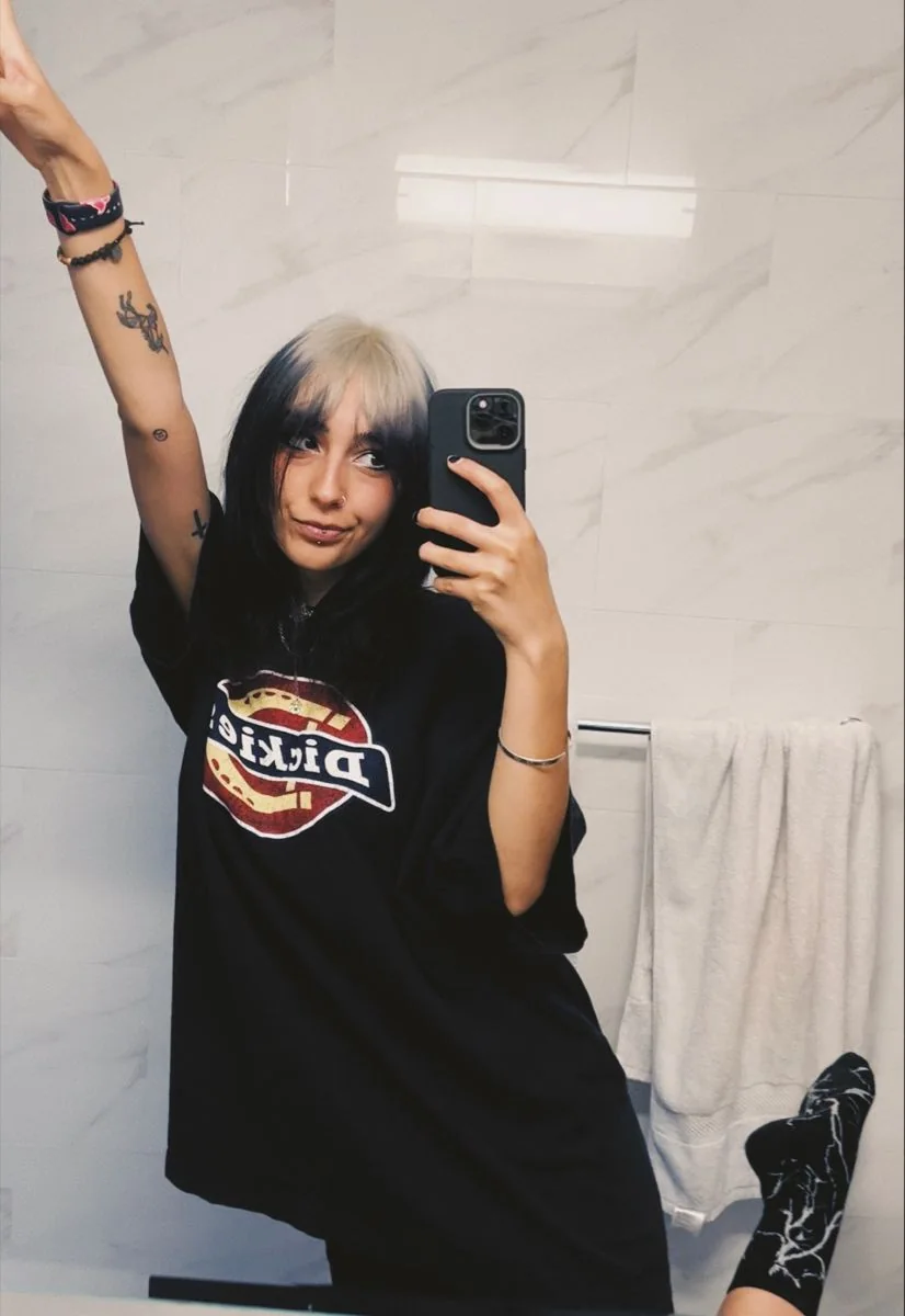 Medium black shag with curtain bangs and silver-white ghost roots.