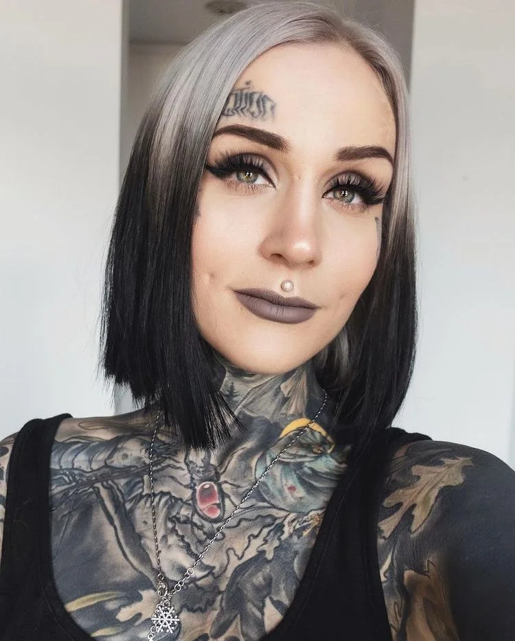 Short black blunt bob with silver-white ghost roots and a center part.
